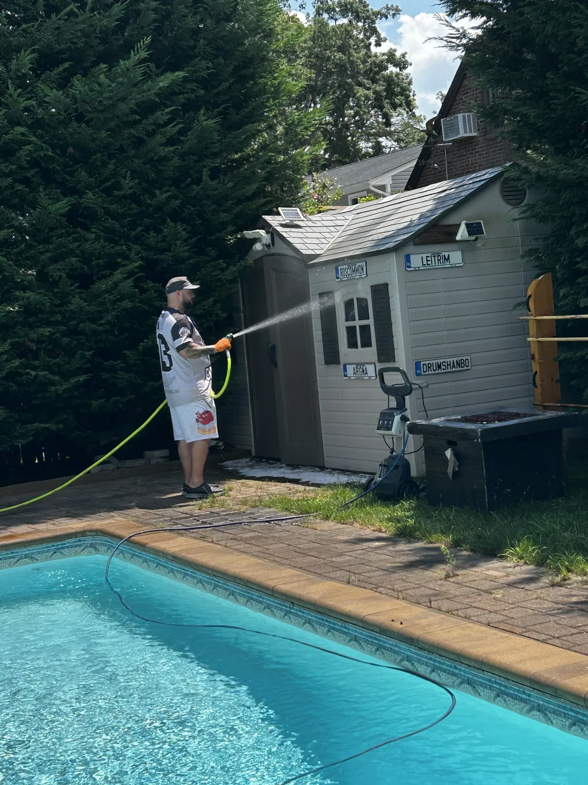 Pressure washing a driveway on Long Island, revealing clean concrete